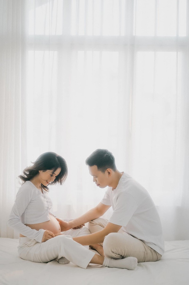 Trong ảnh, vợ chồng Chim Sẻ Đi Nắng chụp trên một phông nền trắng đơn giản. Cả hai cùng mặc đồ đôi màu trắng giản dị, khoe loạt ảnh bụng bầu của thành viên mới cực dễ thương.