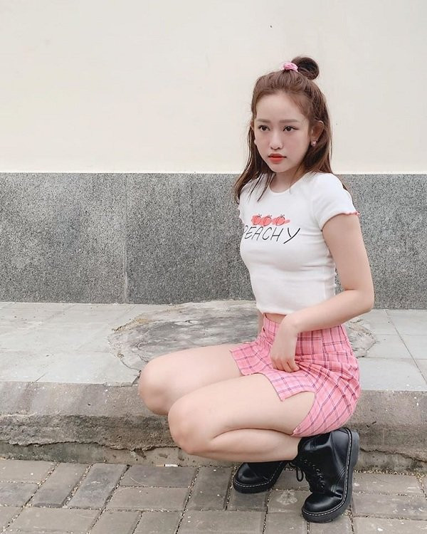 Style trẻ con với kiểu váy hồng sọc ca rô cùng áo thun body của Thúy Vi nhưng cô nàng lại chọn đôi giày đen khá cá tính.