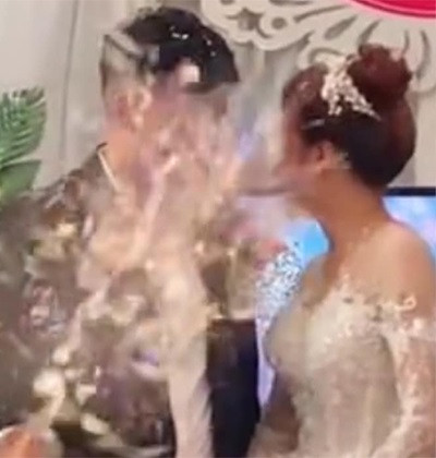 Ánh mắt cô dâu mặc dù đã phát hiện ra điều gì đó bất ổn nhưng chưa kịp tránh thì bị một nam thanh niên mặc áo đen bắn pháo giấy xịt thẳng vào mặt.