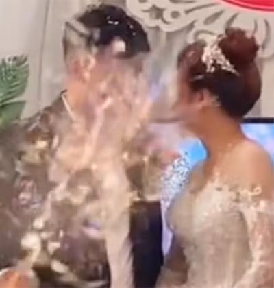 Ánh mắt cô dâu mặc dù đã phát hiện ra điều gì đó bất ổn nhưng chưa kịp tránh thì bị một nam thanh niên mặc áo đen bắn pháo giấy xịt thẳng vào mặt.