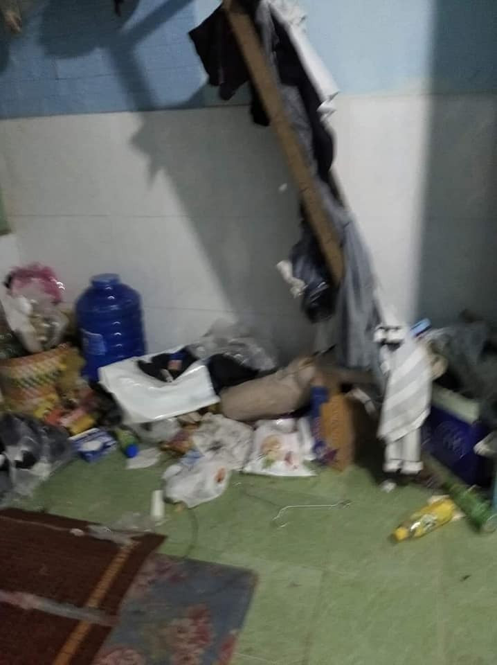 Trên giường, dưới đất, quần áo lẫn lộn đủ loại, hỗn tạp, vỏ gối, vỏ chăn mốc meo vì lâu không giặt.