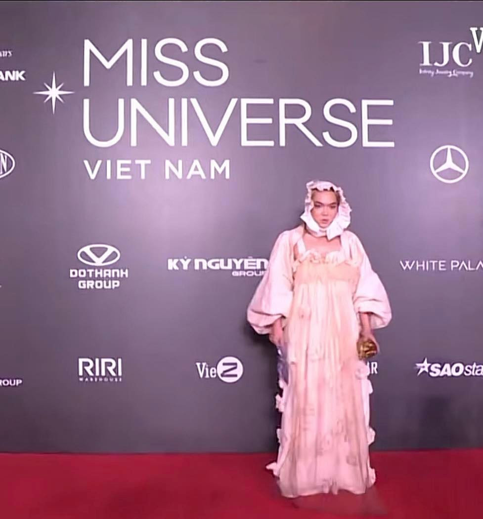 Thảm họa mạng này xuất hiện với trang phục màu trắng be rộng thùng thình và đội mũ như trẻ em. Cùng với đó là lối trang điểm tông nude nhợt nhạt, nhấn nhá và đôi mắt.