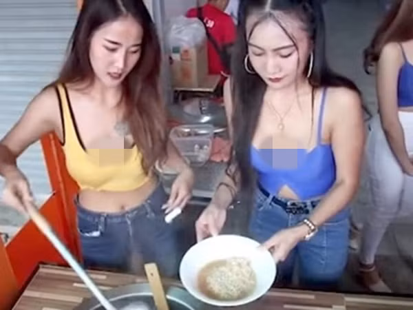 Hai cô gái khác đứng bán quán ăn ăn vận mát mẻ, hở rốn còn trễ nãi, khoe ngực khiến nhiều người lắc đầu. Ảnh Internet