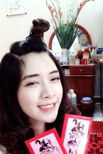 Cách khoe tiền lì xì đáng yêu nhất là các bạn gái trang điểm mặt thật xinh, cầm phong bao lì xì và "tự sướng" trong nhà.