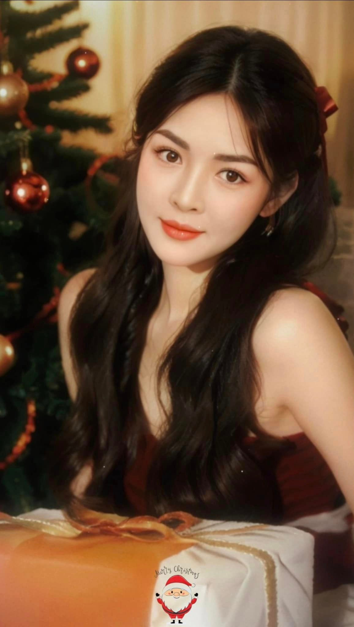 "Siêu phẩm thẩm mỹ Nam Định" diện chiếc váy đỏ chuẩn chủ đề Giáng sinh và trước mặt là hộp quà.