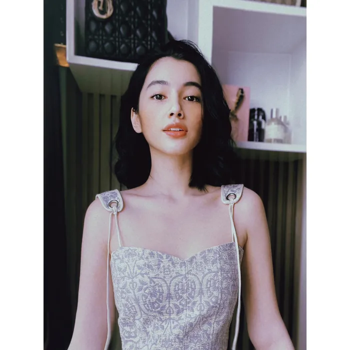 Cẩm Đan trong kiểu áo len hai dây xẻ sâu lộ vòng 1 phẳng lì với dòng caption "Mess im cả ngày -Miss Anh cả ngày"