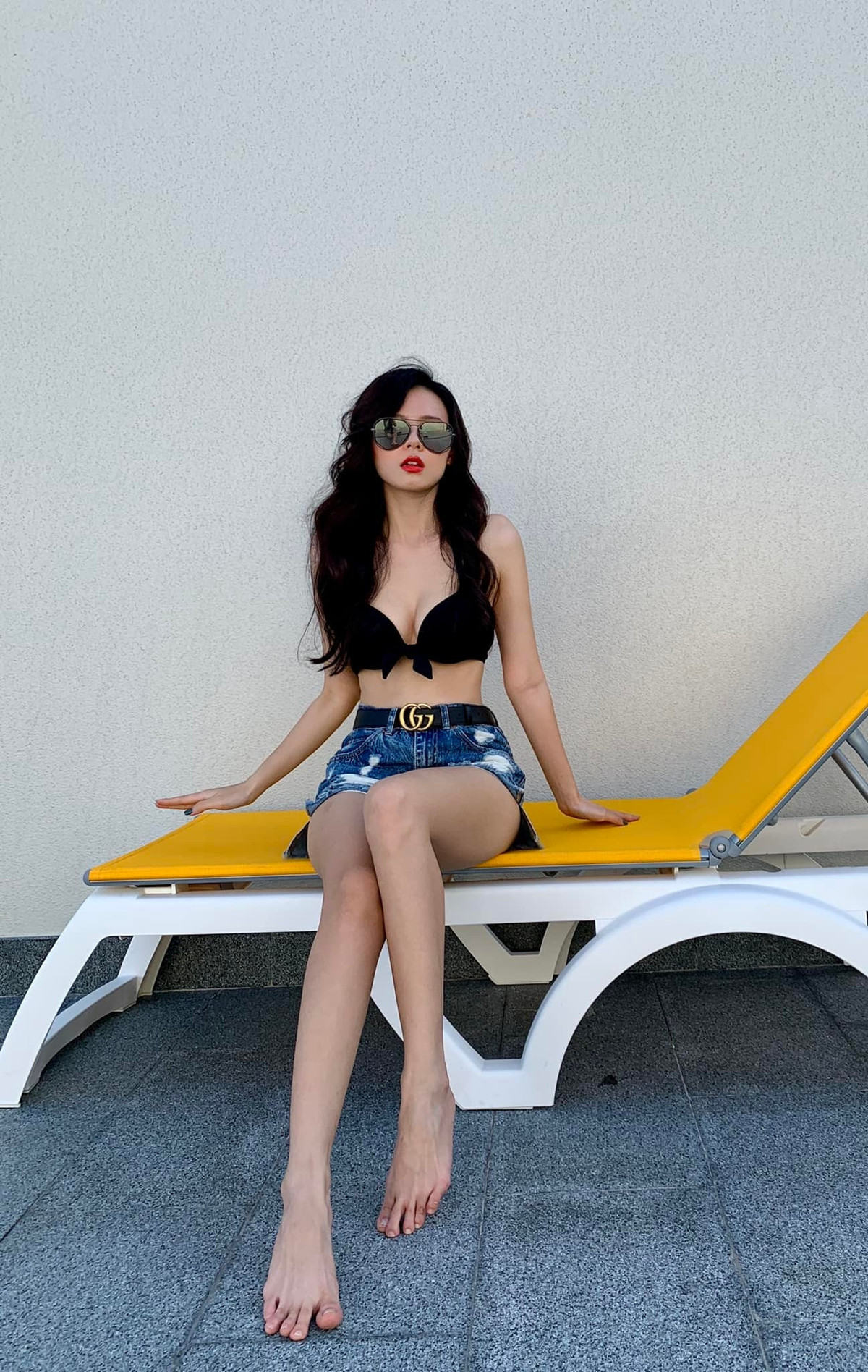 Thay vì diện nguyên bộ bikini, Midu lại thay bắc chiếc quần short jean cùng phụ kiện là chiếc thắt lưng Gucci thời thượng.