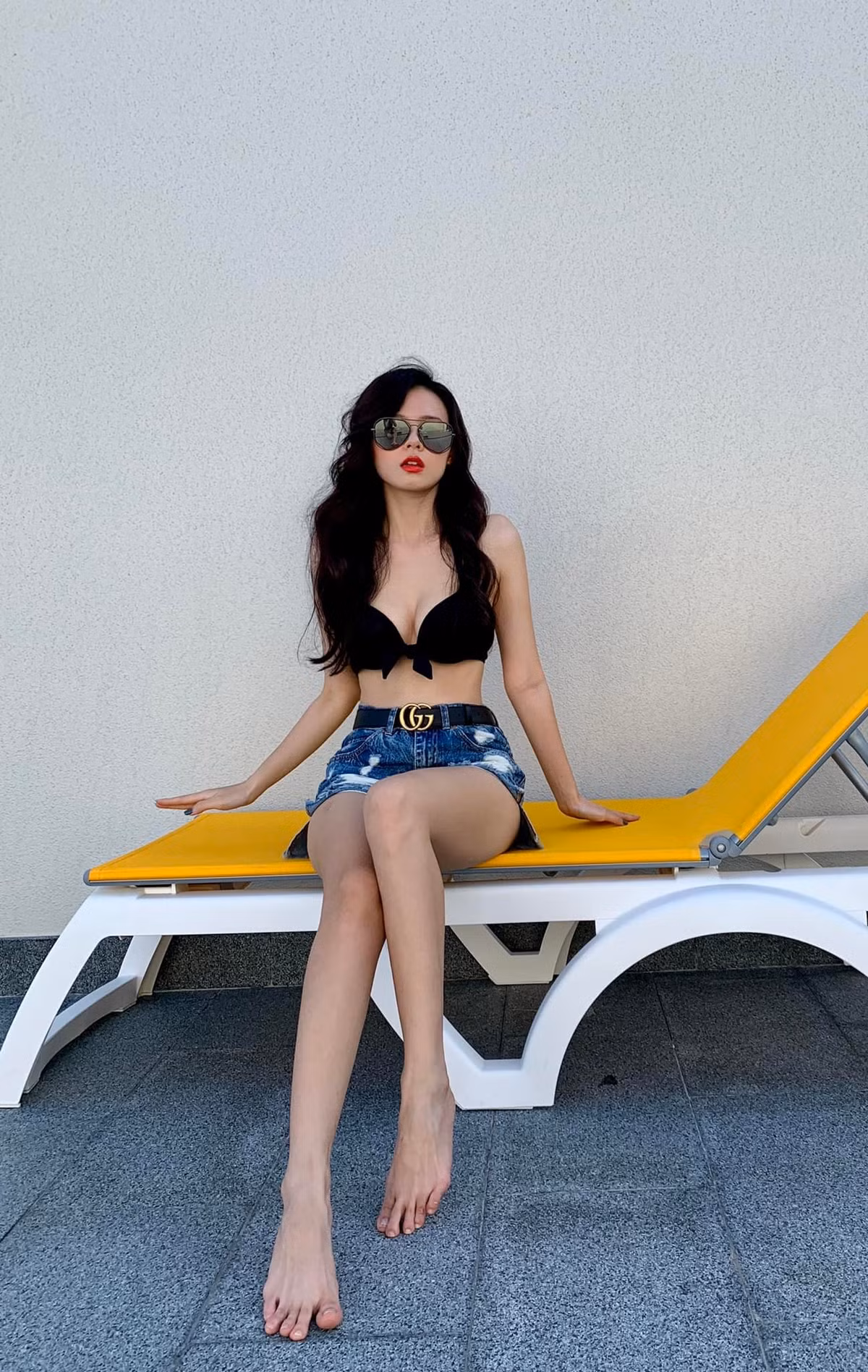 Thay vì diện nguyên bộ bikini, Midu lại thay bắc chiếc quần short jean cùng phụ kiện là chiếc thắt lưng Gucci thời thượng.