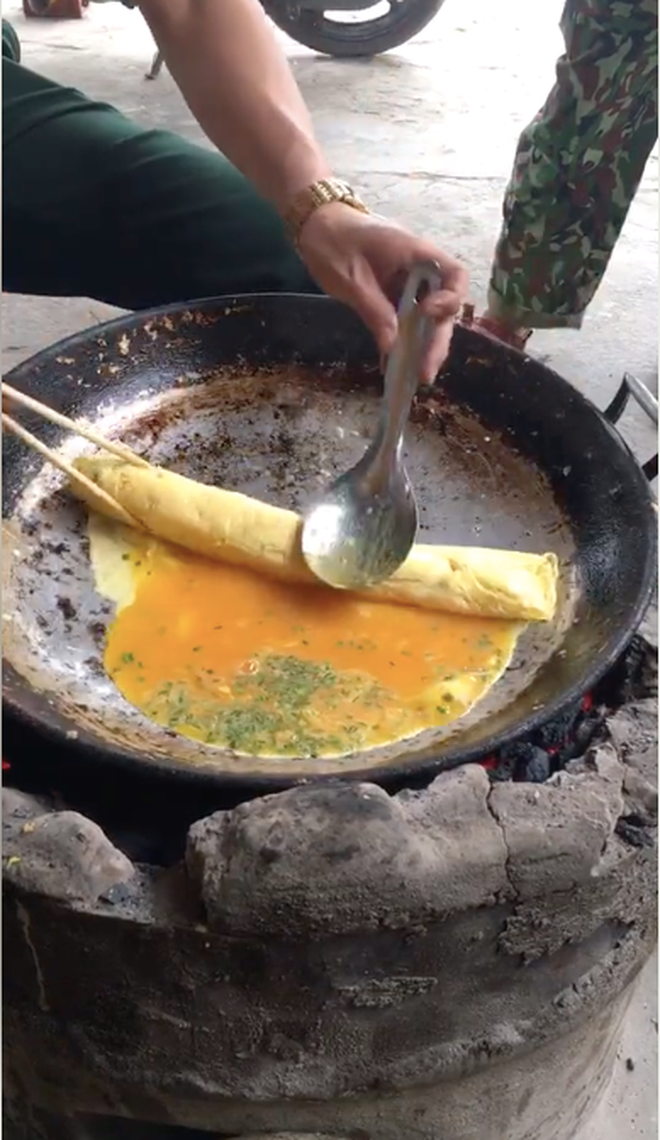 Trong clip, có thể thấy người này làm món trứng cuộn chỉ nhờ vào sự trợ giúp của một cái bếp than, chiếc chảo to, một đôi đũa và cái muỗng.
