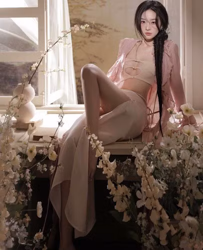 Trong ảnh, nàng hot girl lai Việt - Thái diện thiết kế váy màu nude, với điểm nhấn là chi tiết cut out, tôn vòng 1 đầy đặn, phối cùng chiếc áo choàng màu hồng phớt, tua rua giống sứa biển, mang đậm phong cách Mermaidcore, đang "làm mưa làm gió" trong thời gian gần đây.