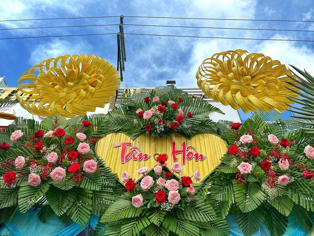 Điểm nhấn của chiếc cổng cưới này chính là cặp long phụng được đính kết tỉ mỉ ở hai bên xen kẽ với hoa tươi khiến chiếc cổng cưới càng thêm rực rỡ.