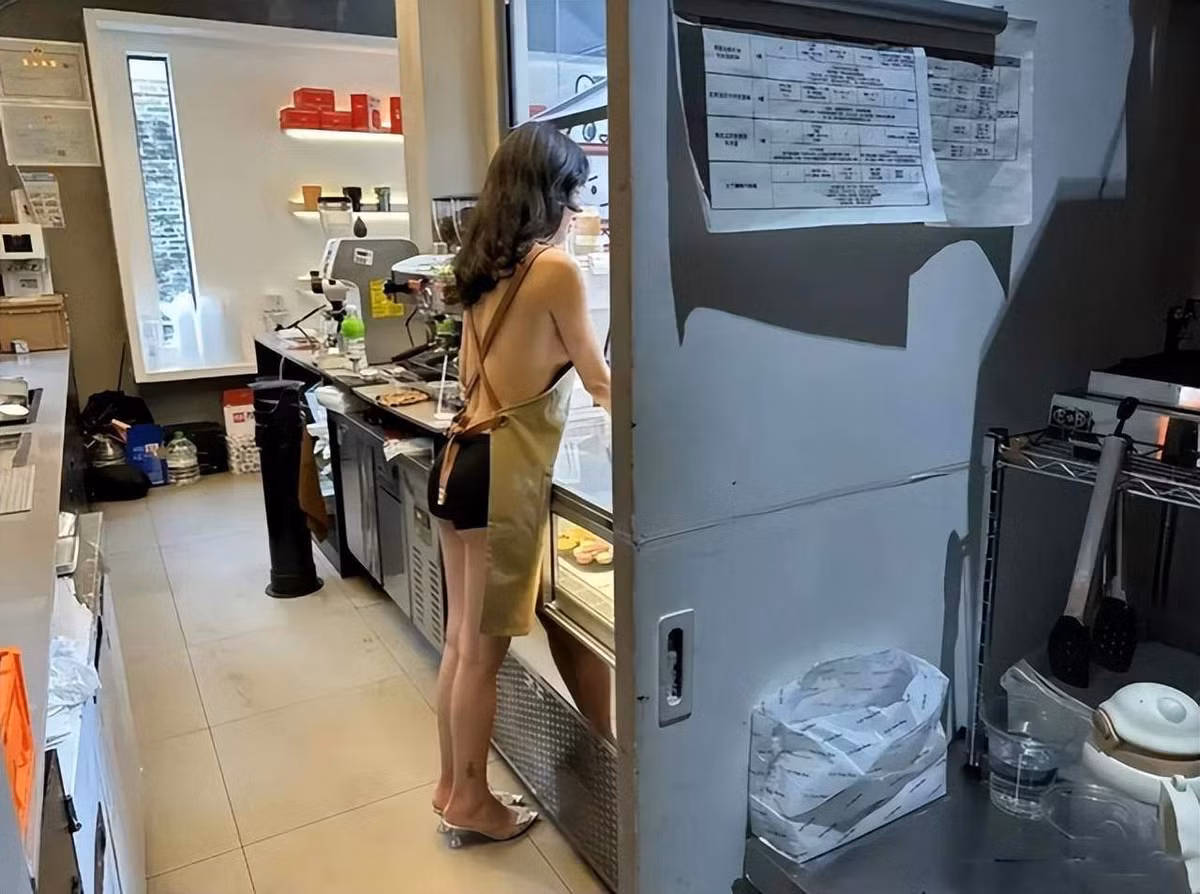 Nữ nhân viên này diện một chiếc váy ngắn khoe đôi chân thon thả cùng làn da trắng sáng, phía trên chỉ mặc chiếc tạp dề. Nhìn từ phía sau thì cô gần như nude phần trên.