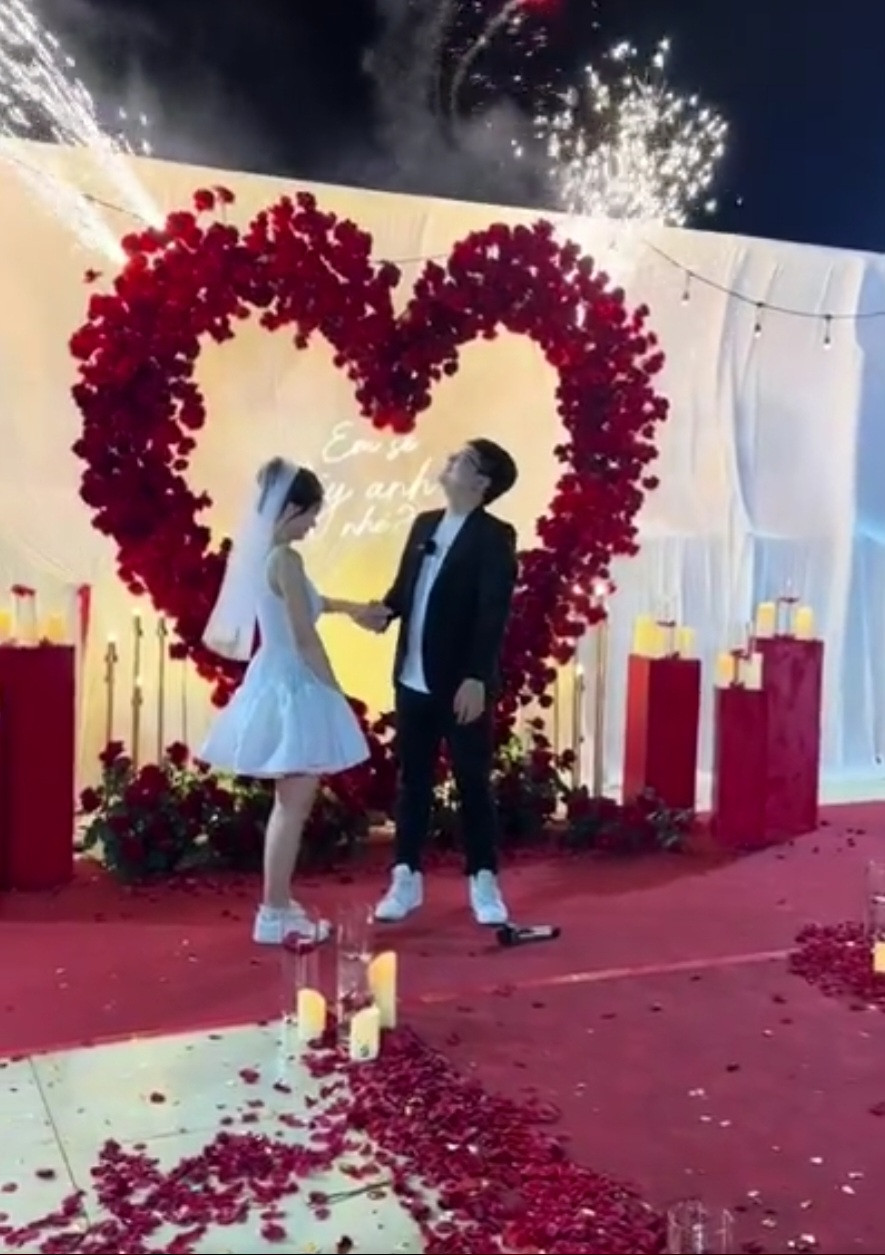 Trong không gian ngập tràn nền và hoa, Win.D quỳ gối trao nhẫn cho nửa kia. Nam Phương trong bộ váy trắng, đầu đội voan gật đầu đồng ý.