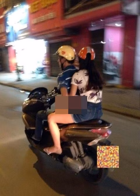 Dù đang điều khiển xe máy nhưng vẫn ngoái tay lại đằng sau "sàm sỡ" bạn gái.