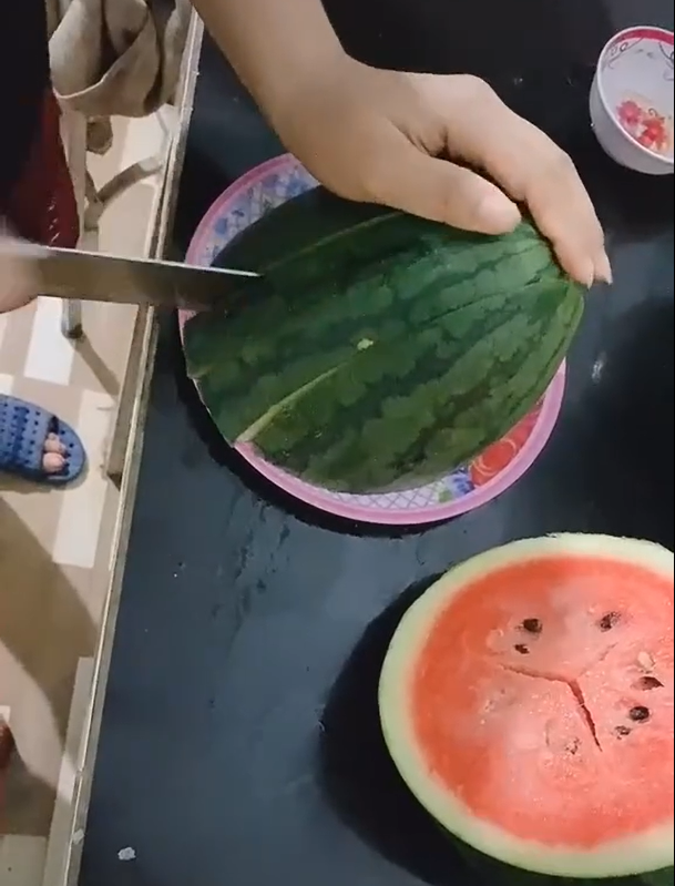 Sau khi giữa lại 2 lát giữa quả dưa, cô gái bày ra đĩa và chia thành miếng vừa ăn.
