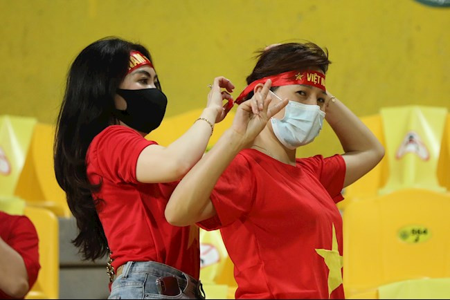 2 nữ CĐV đã giúp nhau thắt chặt tấm băng đô để cổ vũ đội tuyển Việt Nam.