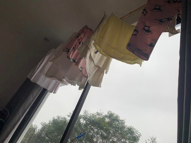 Hình ảnh một gia đình phơi quần áo trẻ em từ đầu nhà đến cuối nhà, đồng thời bật chế độ hút ẩm chỉ để mong quần áo nhanh khô.