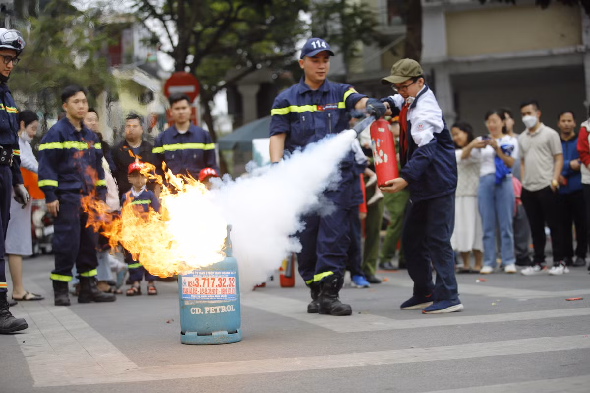 Các em học sinh được hướng dẫn sử dụng bình cứu hỏa cá nhân để tự xử lý đám cháy.