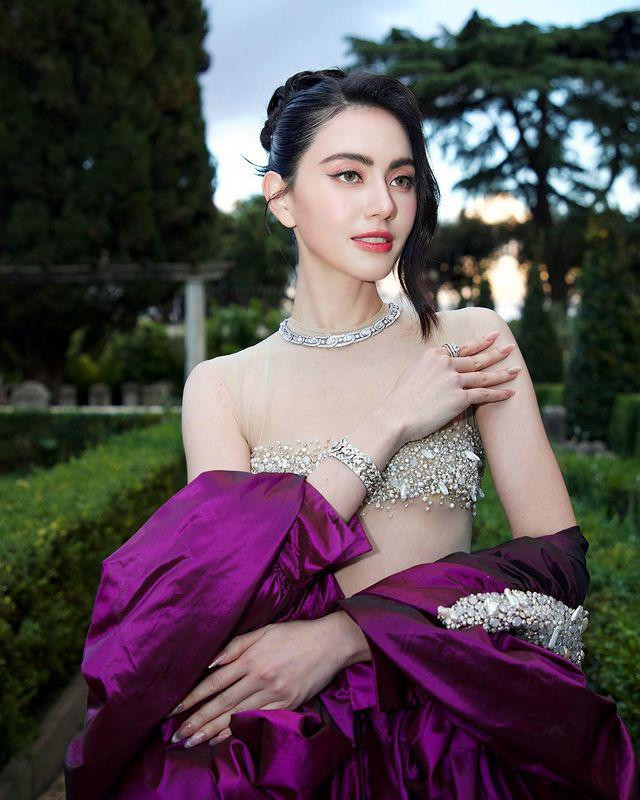 Cô kết hợp cùng chiếc áo choàng dài bên ngoài và váy đồng điệu với màu áo. Vẫn là kiểu tóc búi cao nhưng lần này cô để tóc mái lệch một bên, làm tăng vẻ cá tính, thu hút.