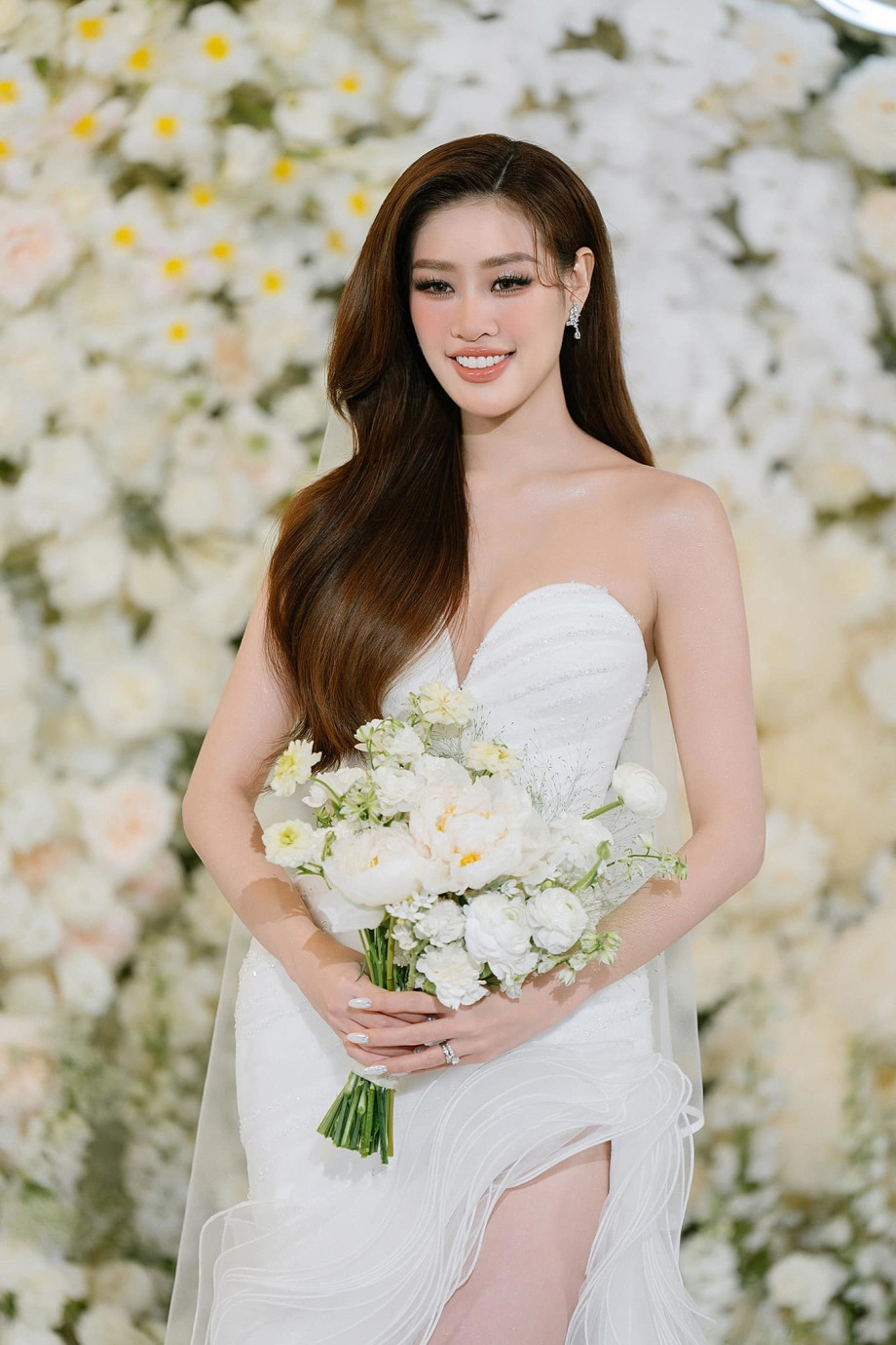 Điểm nhấn đầu tiên là phần cổ sweetheart neck yêu kiều, như một lời thì thầm ngọt ngào, kết hợp hoàn hảo với những chi tiết đính kết đá Swarovski tinh xảo ở phần thân váy, làm sáng bừng mọi khoảnh khắc.