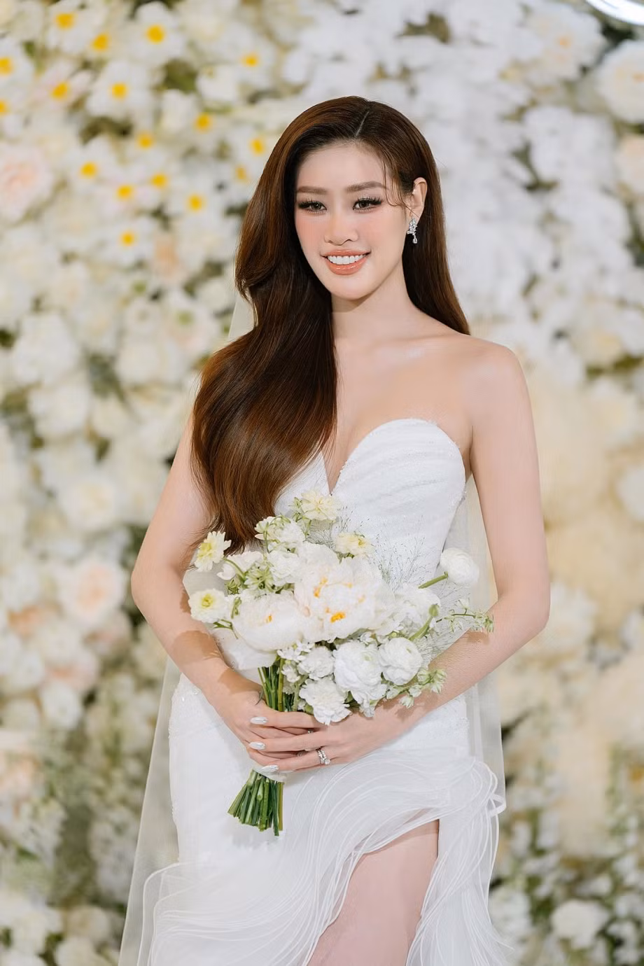 Điểm nhấn đầu tiên là phần cổ sweetheart neck yêu kiều, như một lời thì thầm ngọt ngào, kết hợp hoàn hảo với những chi tiết đính kết đá Swarovski tinh xảo ở phần thân váy, làm sáng bừng mọi khoảnh khắc.