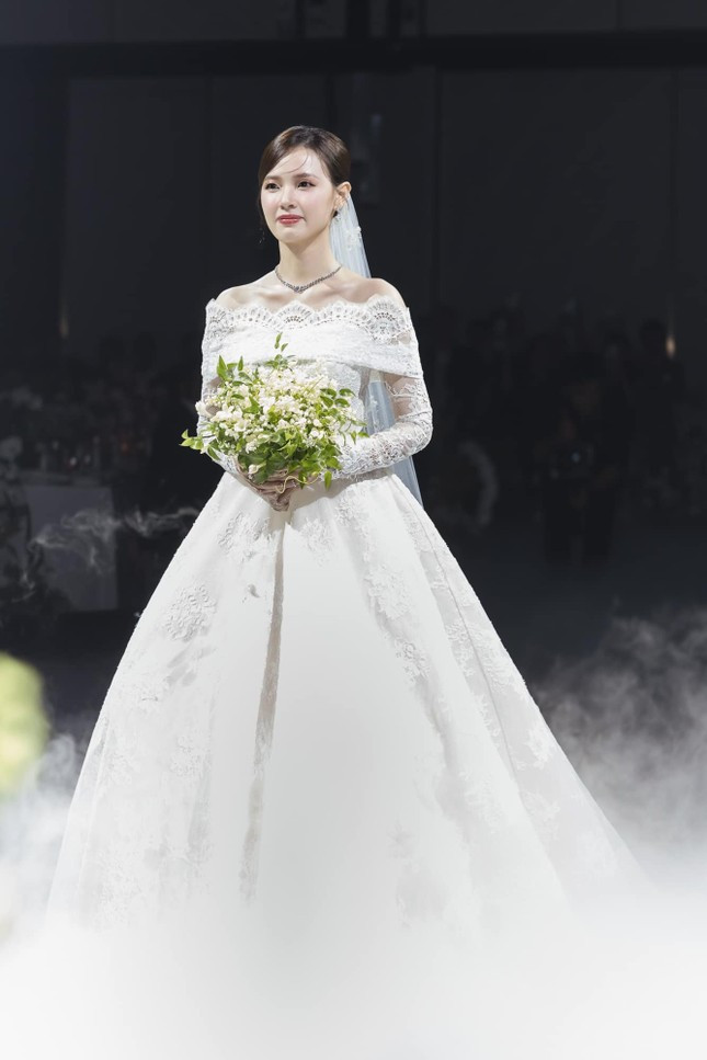 Chiếc váy cưới thứ hai được Midu chọn bước vào lễ đường làm lễ với chồng thuộc BST Thu Đông 2024 có chung nhà mốt, có tên "Of Diamond Dust" được lấy cảm hứng từ kỷ nguyên Art Deco kết hợp cùng sự quyến rũ của Old World.