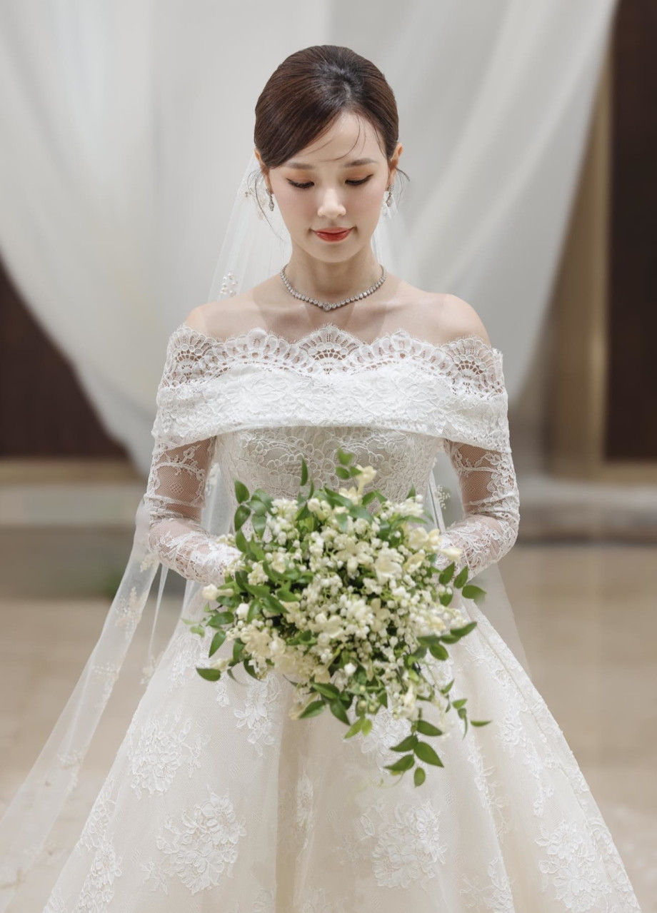 Midu sử dụng hai chiếc váy đến từ Ellie Saab cho hai thời khắc quan trọng nhất của cuộc đời mình là đón khách và làm lễ. Váy đón khách thuộc BST Xuân Hè 2023 tên "sự rạng rỡ thanh tao" với kiểu dáng trễ vai với chất liệu vải tuyn với nhiều họa tiết thêu hoa. Mẫu váy này được định giá khoảng 19.000 USD (tương đương 484 triệu đồng).