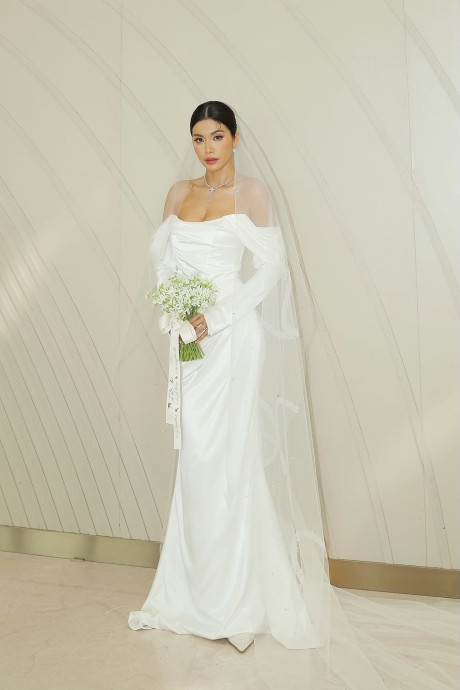 Bộ trang phục được Minh Tú chọn khi làm lễ là chiếc đầm trắng cúp ngực đơn giản với chất liệu cao cấp kèm theo chiếc lúp voan dài.