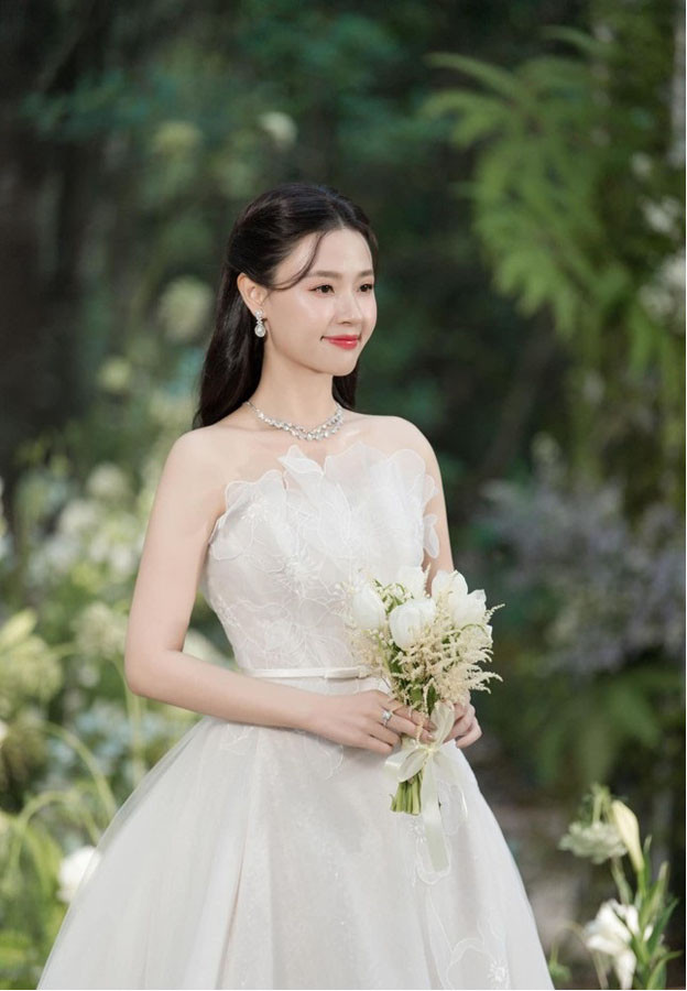 Theo mô tả, chất liệu được sử dụng cho chiếc váy cưới của Midu là ren Chantilly tinh xảo kết hợp phom dáng dạ hội chữ A, trễ vai thể hiện đúng tinh thần nữ tính, sang trọng nhưng không kém phần cổ điển cho cô dâu. Trị giá của chiếc đầm lên đến 26.000 USD (tương đương 660 triệu đồng).