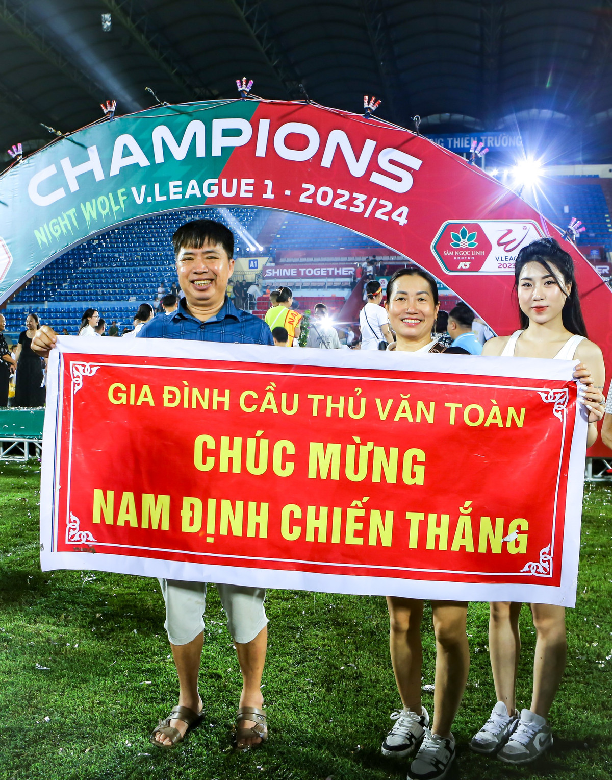 Bố mẹ và Nguyễn Nụ xuống sân để chung vui với danh hiệu đầu tiên của Văn Toàn sau ngần ấy năm miệt mài thi đấu.