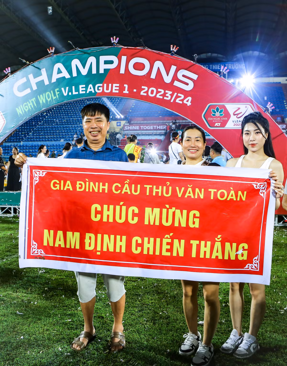 Bố mẹ và Nguyễn Nụ xuống sân để chung vui với danh hiệu đầu tiên của Văn Toàn sau ngần ấy năm miệt mài thi đấu.