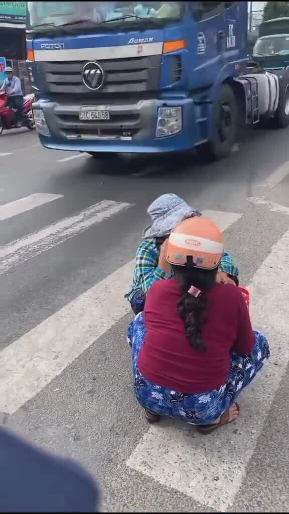 Mặc cho dòng xe cộ đi lại như mắc cửi nhưng hai người phụ nữ trên vẫn ngang nhiền ngồi nói chuyện như trước hiên nhà.