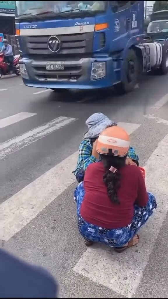 Mặc cho dòng xe cộ đi lại như mắc cửi nhưng hai người phụ nữ trên vẫn ngang nhiền ngồi nói chuyện như trước hiên nhà.