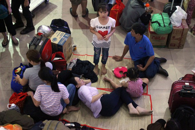 Do bên trong quá tải nên nhiều người ra ngoài sân ga trải chiếu nằm nghỉ ngơi, chờ đợi tới chuyến của mình để về quê.