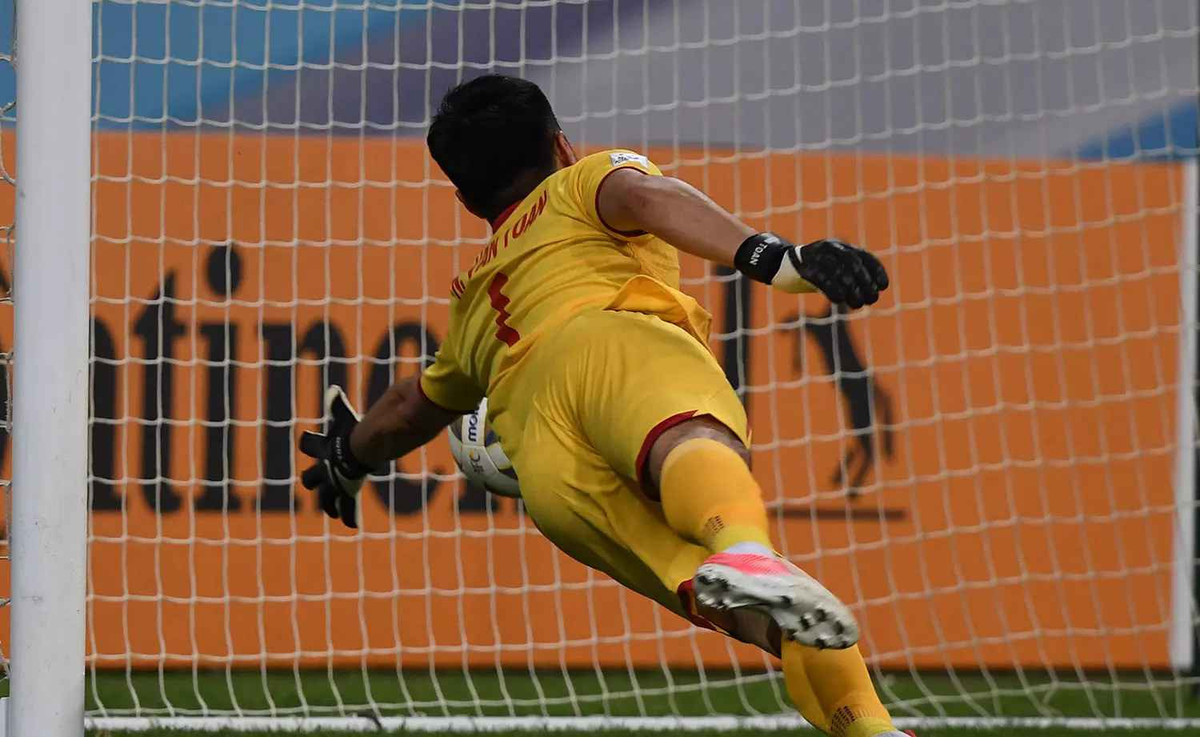 Văn Toản phán đoán bóng bay qua xà ngang, nhưng khi phát hiện ra bóng đang bật vào khung thành trống anh đã không kịp cản phá