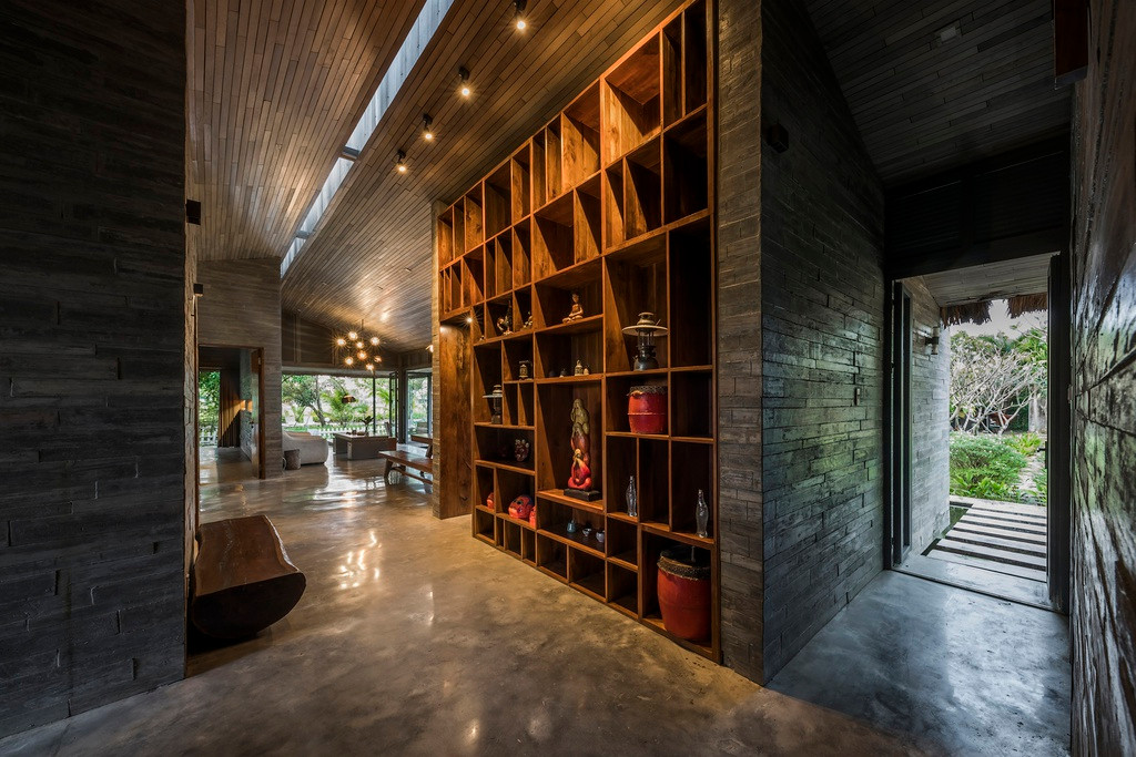 Hệ thống mái che 3 lớp giúp ngôi nhà có thể tự giảm nhiệt và giữ nhiệt độ trong nhà thấp hơn ngoài trời. Toàn bộ trần gỗ được sơn cùng màu với tường bê tông ốp gỗ.