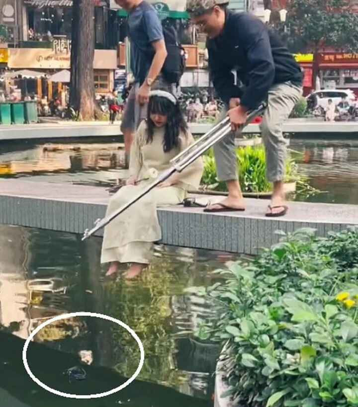 Chỉ vì mải chụp mà cô nàng bị trôi mất chiếc dép và phải nhờ đồng đội vớt lên.