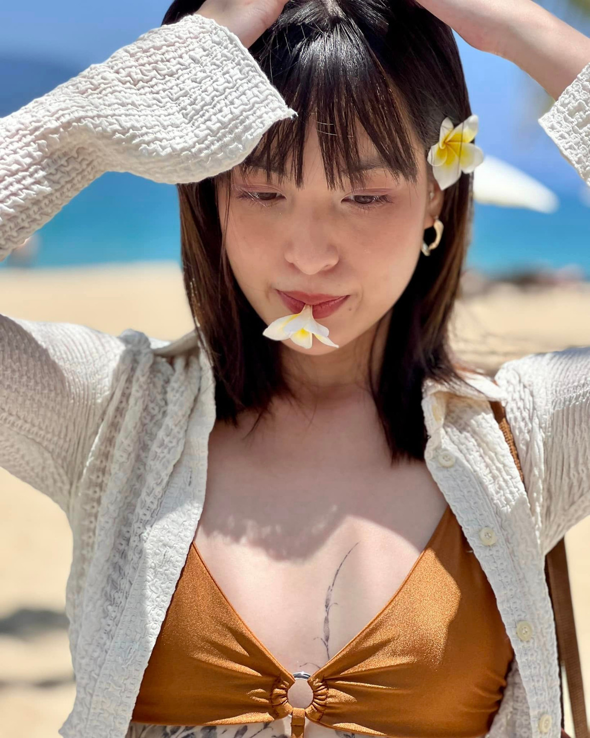 Để tránh ánh nắng, Thảo Tâm khoác chiếc áo trắng dáng lửng, ống tay loe, không cài khuy áo. Chiếc túi xách dạng lưới đồng màu với set bikini là món phụ kiện hoàn thiện bộ đồ đi biển vừa quyến rũ vừa trẻ trung, năng động, cá tính này.