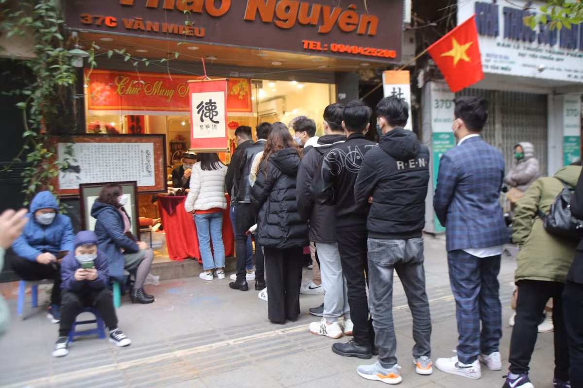 Sĩ tử xếp hàng dài xin chữ trên vỉa hè phố Văn Miếu.