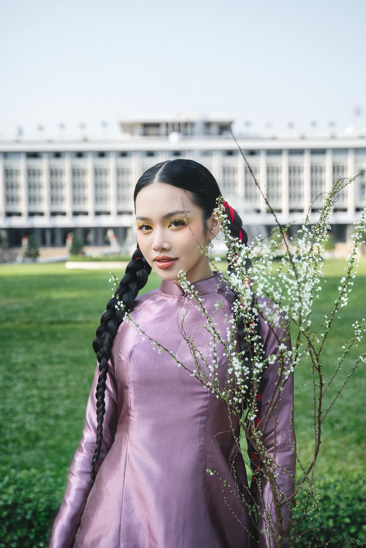 Nữ ca sĩ sinh năm 2002 diện áo dài tông hồng làm từ chất liệu organza, phom cổ điển, ống tay suôn nhưng vẫn có phần chiết eo, giúp cô khoe vóc dáng "mình hạc xương mai".