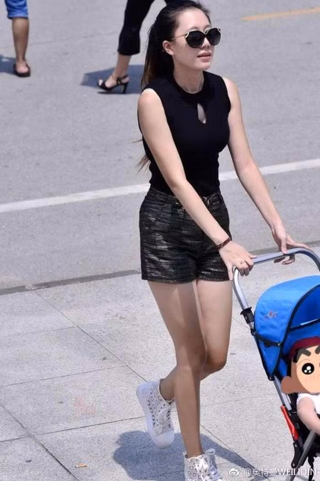 Như trường hợp của một bà mẹ người Trung Quốc trên đây. Người đi đường tình cờ gặp cô và chụp lại khoảnh khắc người đẹp dắt con trai xuống phố. Cô chọn cho mình trang phục hai dây kiểu cổ chữ V bó sát.