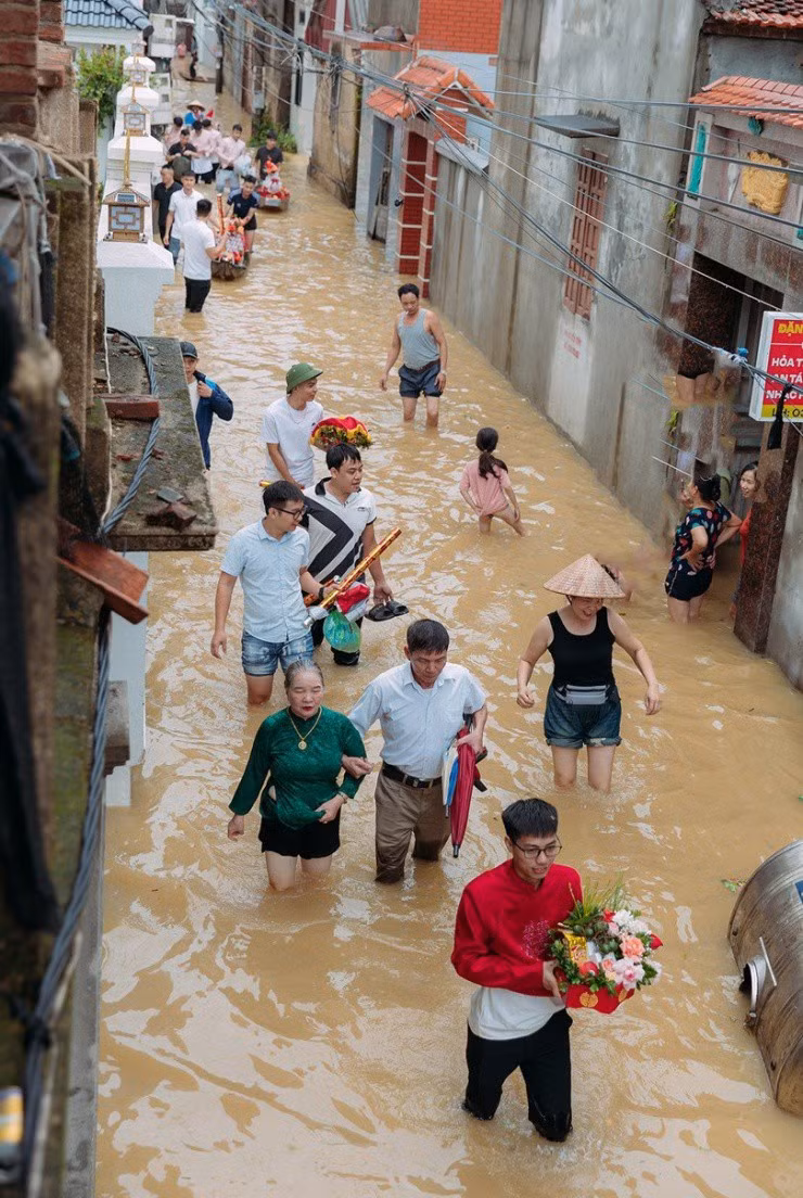 Gây chú ý hơn cả là hình ảnh chú rể cầm hoa cưới, dàn phù rể bê tráp cưới cùng các quan khách bì bõm lội nước sang nhà gái rước dâu.