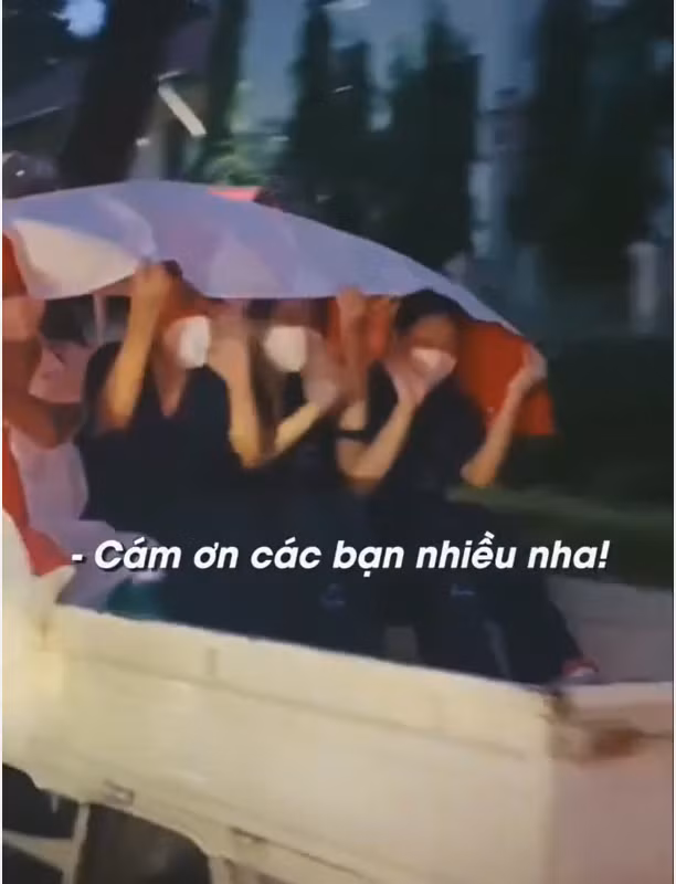 Giữa cơn mưa tầm tã như trút nước của buổi chiều muộn, cả nhóm tình nguyện viên chỉ có một chiếc bạt lớn che trên đầu để tránh bị ướt.