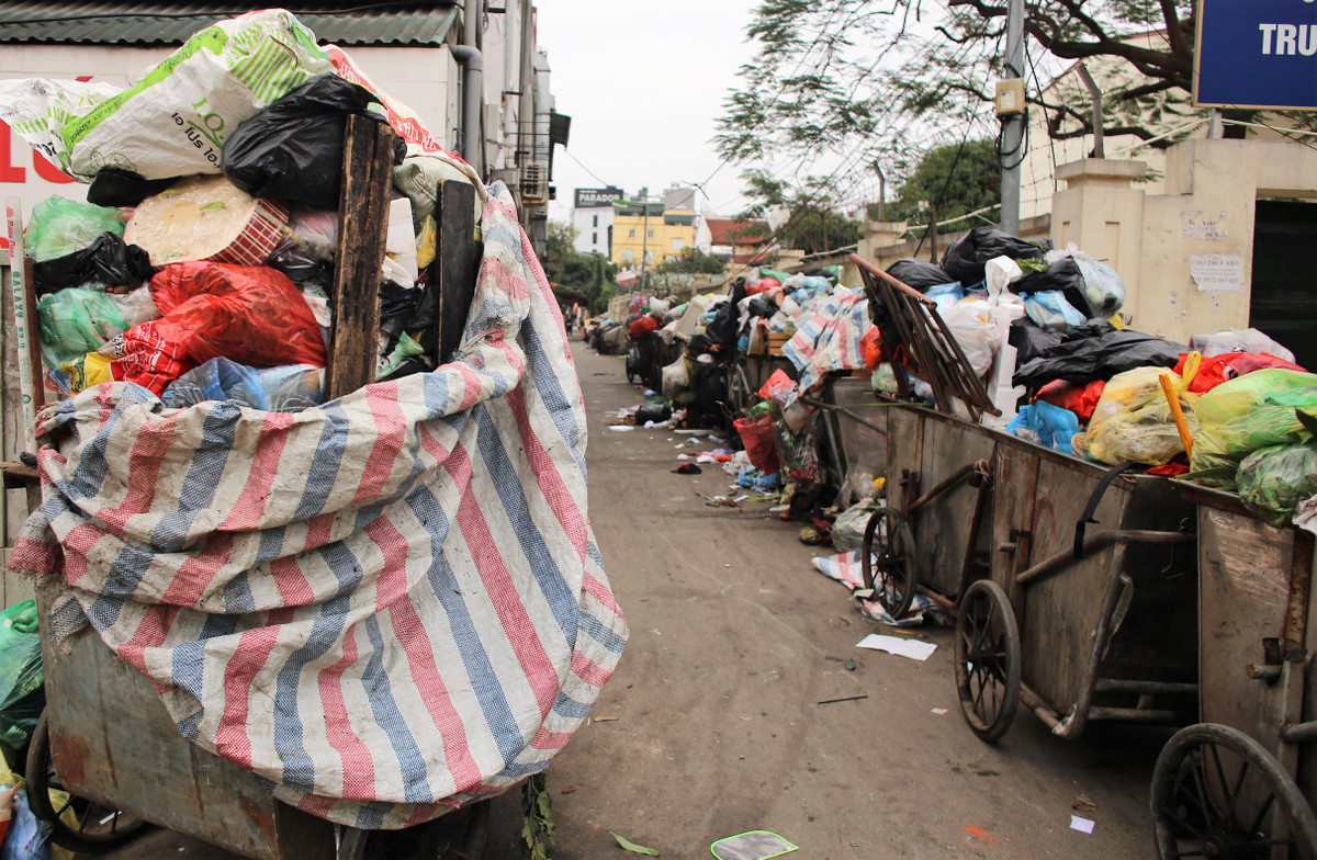 Có mặt tại khu vực quận Đống Đa, nơi Xí nghiệp Môi trường Đô thị số 4 (URENCO 4) quản lý, PV ghi nhận những xe rác cao quá đầu người và nằm chờ xe cẩu đến mang đi.