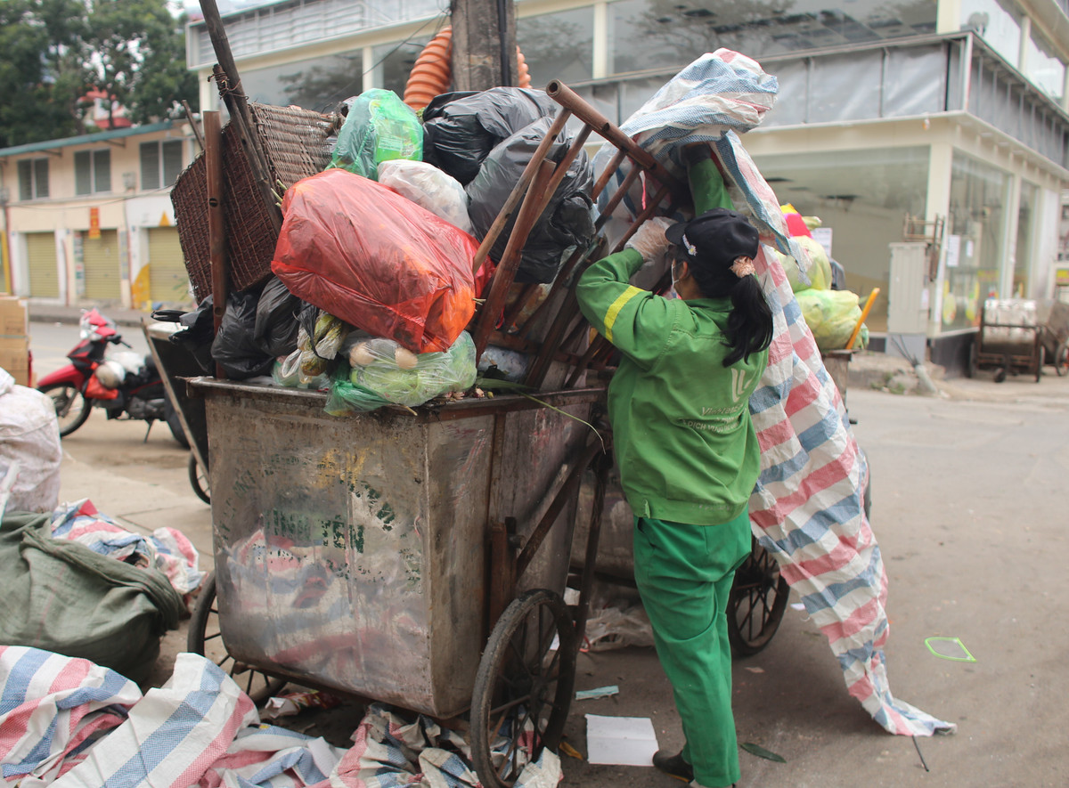 Cũng theo nữ công nhân của tổ 5 - Xí nghiệp Môi trường Đô thị số 4 trên cho biết, kể từ sáng đến 12h trưa, chưa có bất cứ chuyến cẩu nào giải phóng rác và họ vẫn phải ngồi chờ để lấy phương tiện đi làm. Trong khi, rác vẫn cứ ùn ùn được vứt ra đường từ khắp các ngõ xóm.