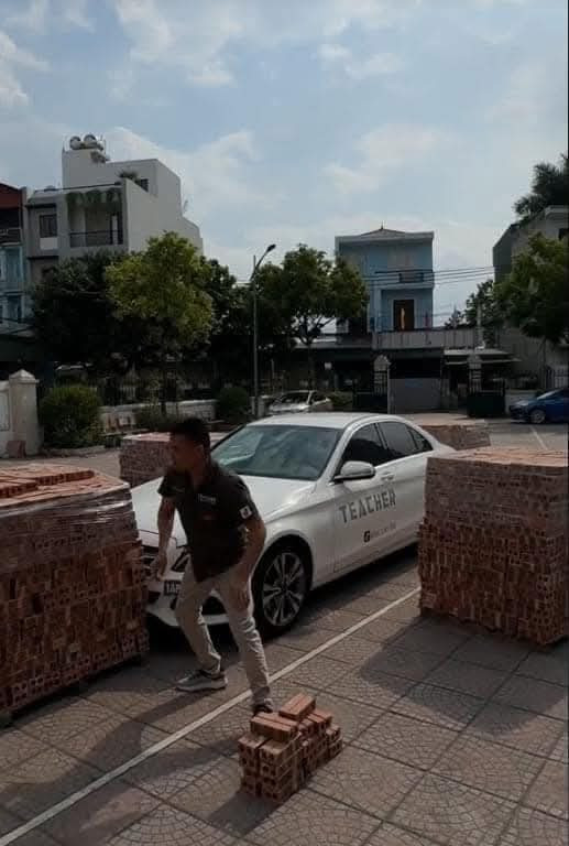 Khi phát hiện xe bị người "bao vây" bằng những khối gạch to, "thầy dạy lái xe" có biểu cảm khó đỡ.