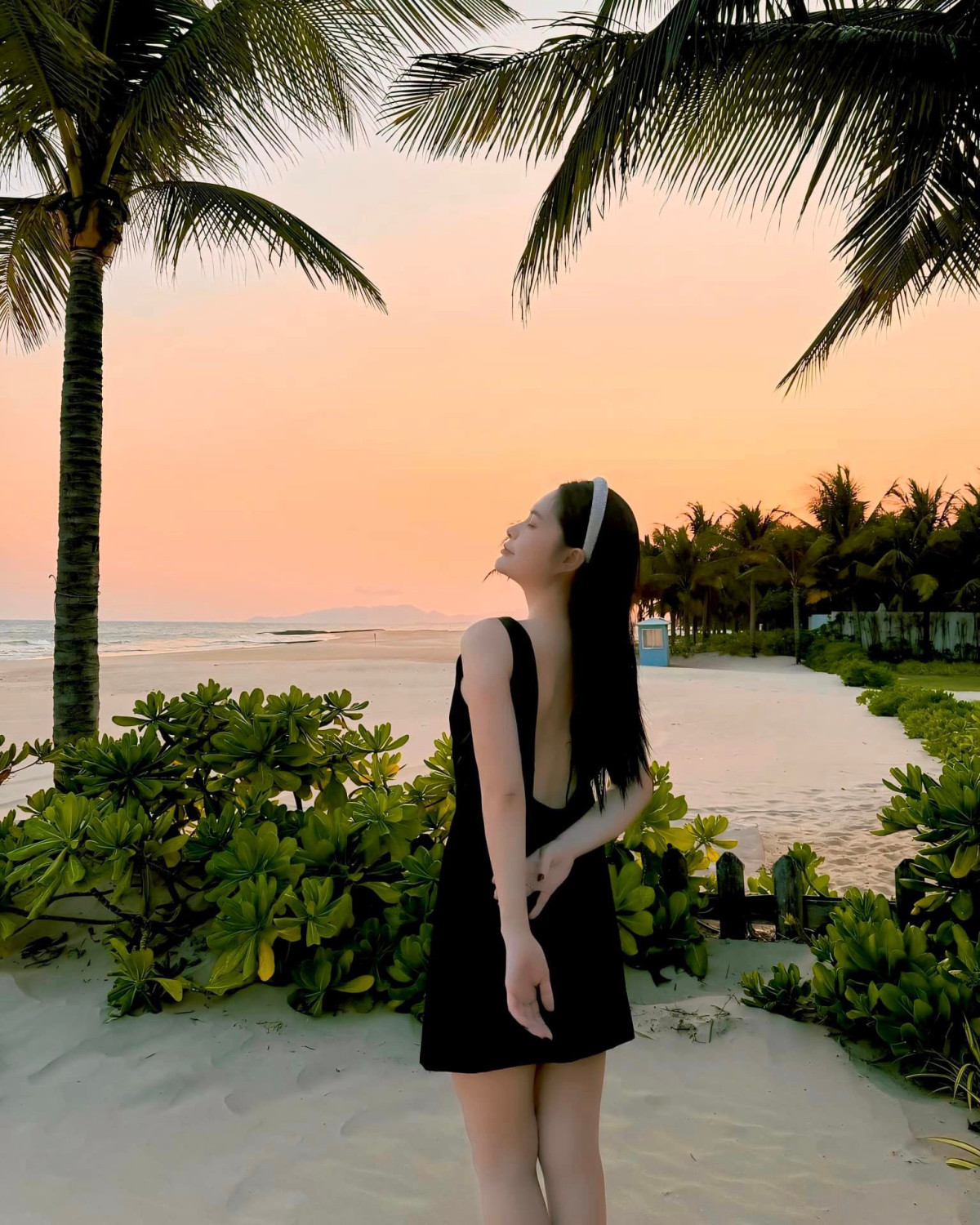 Đoàn Di Băng ngắm hoàng hôn ở Hồ Tràm cùng bộ đồ liền khoét lưng sâu.