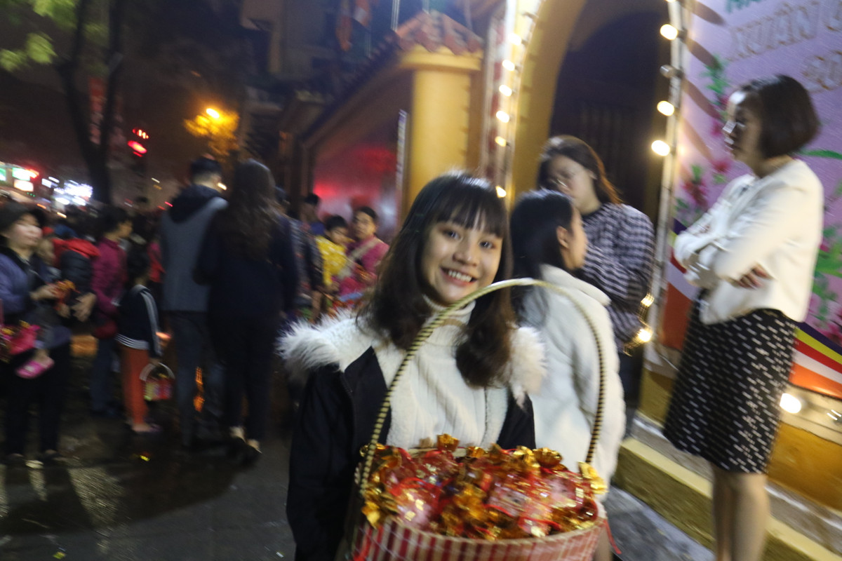 Phía bên ngoài chùa Quán Sứ, nhiều bạn trẻ cũng tranh thủ bán muối phục vụ những người đi lễ chùa.