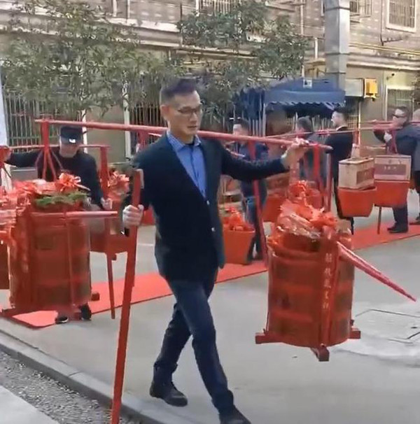 Trong video đám cưới khủng, đội ngũ nhà trai hùng hậu xếp hàng nghiêm chỉnh, mang theo 18 quang gánh sính lễ đến nhà gái.