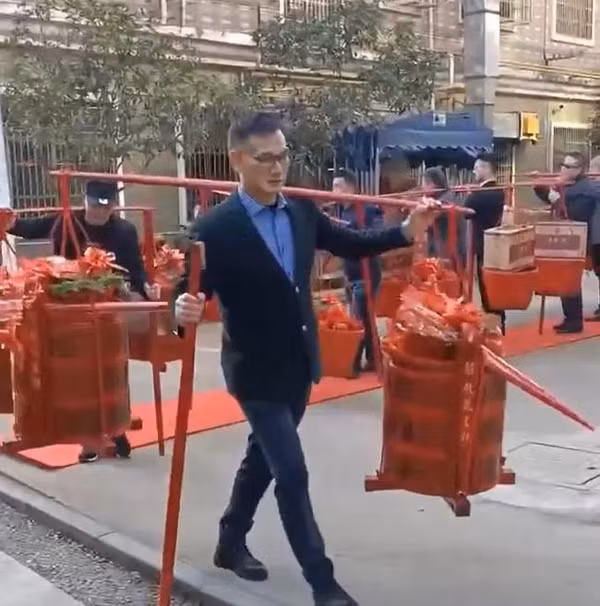 Trong video đám cưới khủng, đội ngũ nhà trai hùng hậu xếp hàng nghiêm chỉnh, mang theo 18 quang gánh sính lễ đến nhà gái.